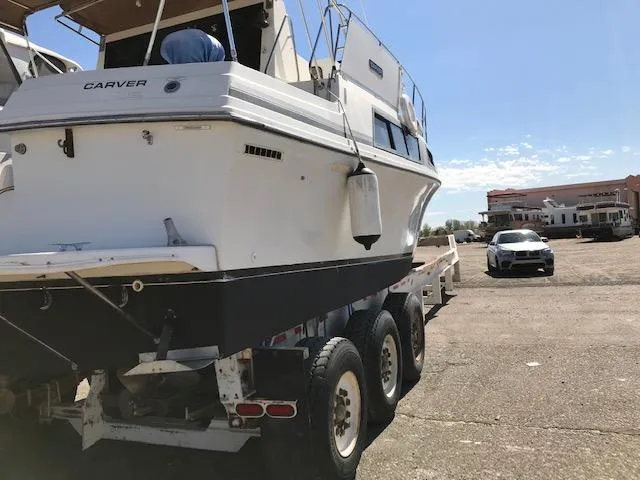 Slide: The Image of 1986 Carver Mariner 32x14.3 boat on trailer in sunny outdoor setting. - 11