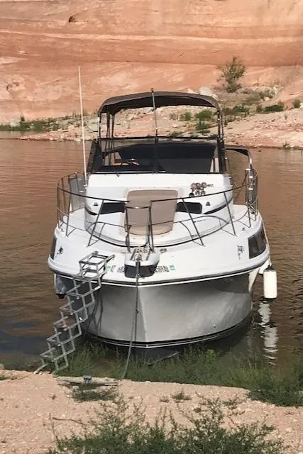 Slide: The Image of 1986 Carver Mariner 32x14.3 boat docked by rocky shoreline. - 12