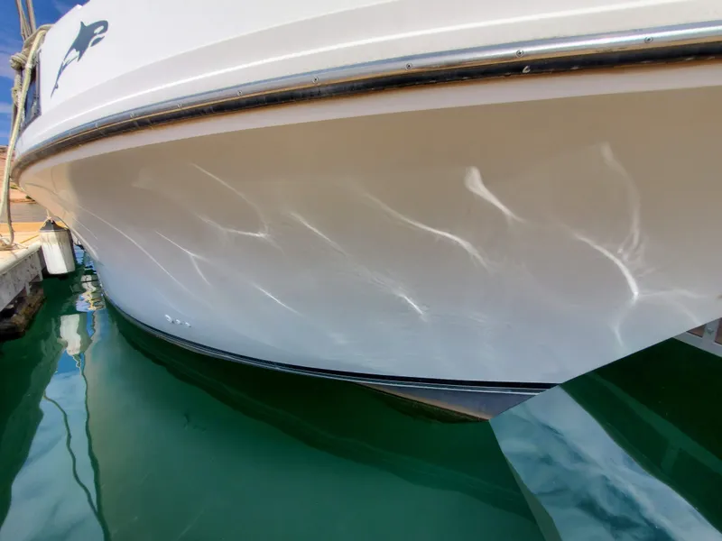 Slide: The Image of 1986 Carver Mariner 32x14.3 boat hull reflecting on calm water. - 22
