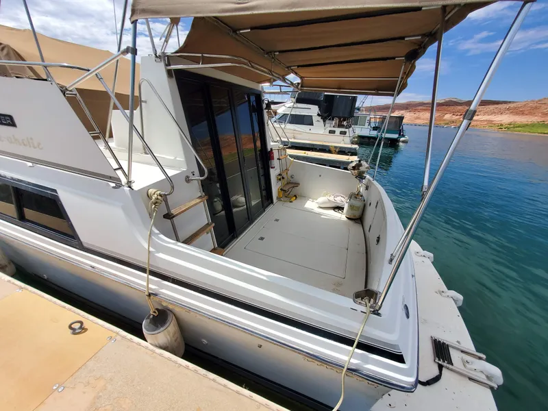 Slide: The Image of 1986 Carver Mariner 32x14.3 boat docked, featuring spacious deck and canopy. - 26