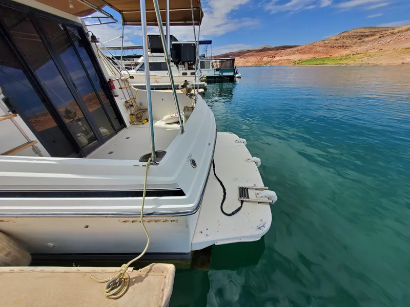 Slide: The Image of 1986 Carver Mariner 32x14.3 docked on clear blue water, sunny day. - 27