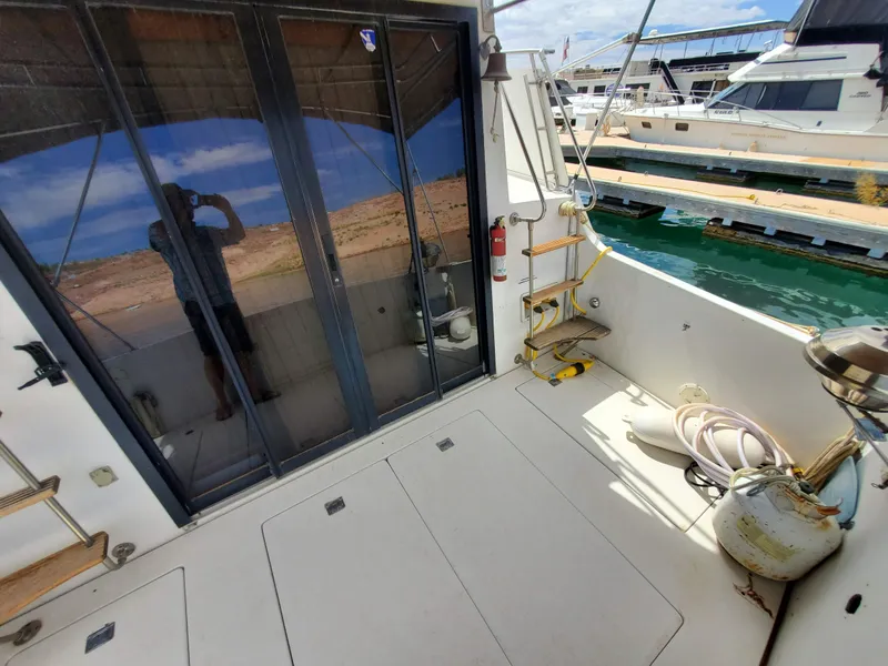 Slide: The Image of 1986 Carver Mariner 32x14.3 boat deck with marina view, featuring sliding glass doors. - 28