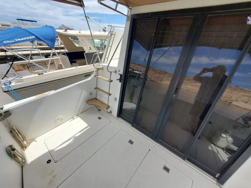 Slide: The Image of 1986 Carver Mariner 32x14.3 yacht deck with sliding glass doors and marina view. - 29