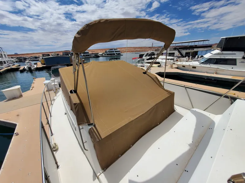 Slide: The Image of 1986 Carver Mariner 32x14.3 boat with tan canopy docked at marina. - 30