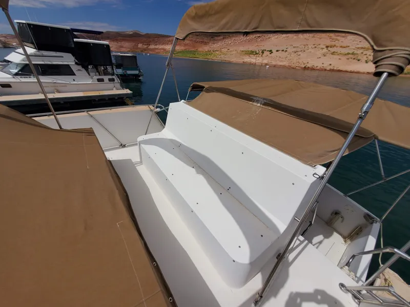 Slide: The Image of 1986 Carver Mariner 32x14.3 boat with tan canopy, docked on a sunny day. - 31