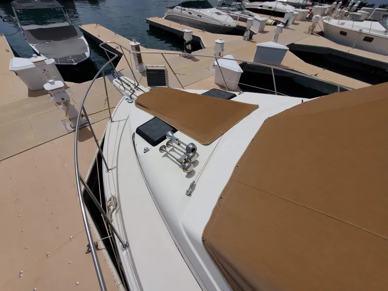 Slide: The Image of 1986 Carver Mariner 32x14.3 yacht docked at marina, featuring tan covers and sleek design. - 32