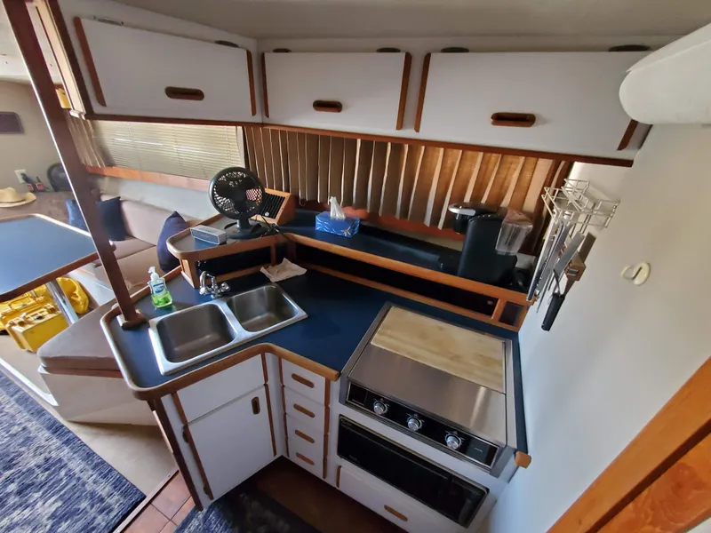 Slide: The Image of 1986 Carver Mariner 32x14.3 boat kitchen with stove, sink, and storage cabinets. - 42