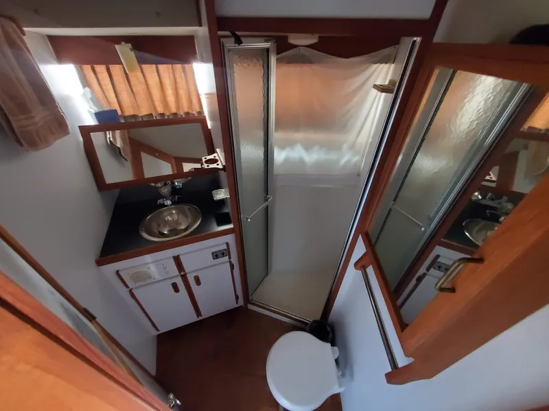 Slide: The Image of 1986 Carver Mariner 32x14.3 bathroom with shower, sink, and mirror. - 43