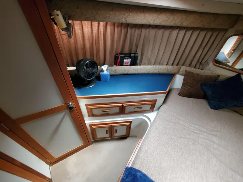 Slide: The Image of 1986 Carver Mariner 32x14.3 cabin interior with bed, drawers, and fan. - 46