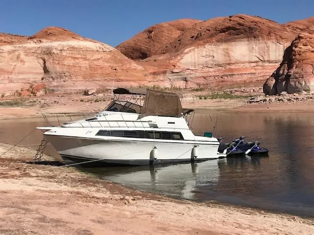 Slide: The Image of 1986 Carver Mariner 32x14.3 yacht docked by red rock cliffs and calm water. - 5