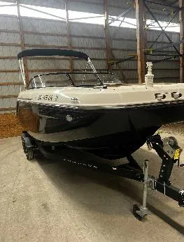 Slide: The Image of 2021 Bayliner DX 2250 boat in a storage facility, black and white exterior. - 11