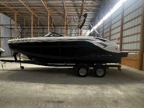 Slide: The Image of 2021 Bayliner DX 2250 boat on trailer in a spacious indoor storage facility. - 13