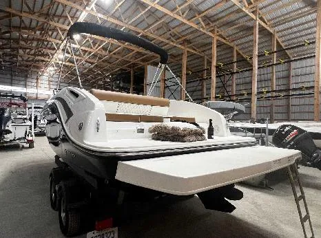 Slide: The Image of 2021 Bayliner DX 2250 boat in storage, showcasing spacious deck and seating. - 14