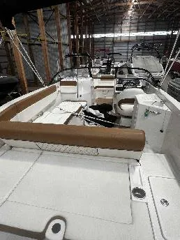 Slide: The Image of 2021 Bayliner DX 2250 boat interior with seating and controls in a storage facility. - 15