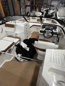 Slide: The Image of 2021 Bayliner DX 2250 boat interior with seating and steering wheel in storage. - 16