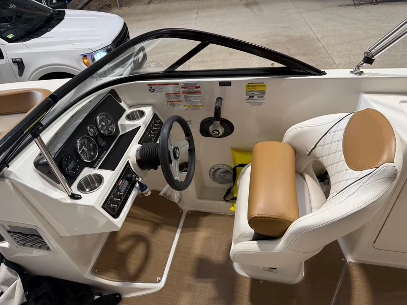 Slide: The Image of 2021 Bayliner DX 2250 boat cockpit with steering wheel and dashboard controls. - 7