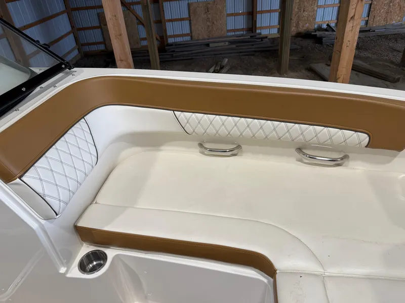 Slide: The Image of 2021 Bayliner DX 2250 boat interior with tan and white cushioned seating. - 9