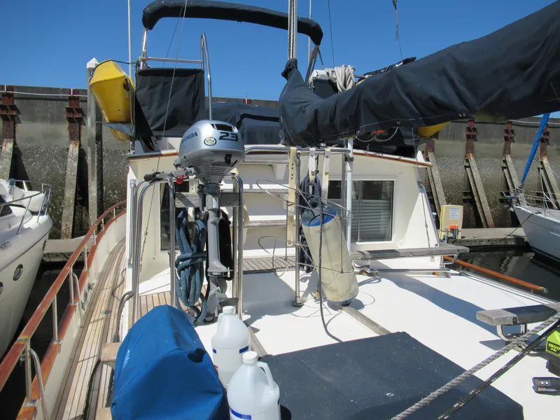 Slide: The Image of 1990 Grand Banks Classic boat docked, featuring deck equipment and outboard motor. - 3