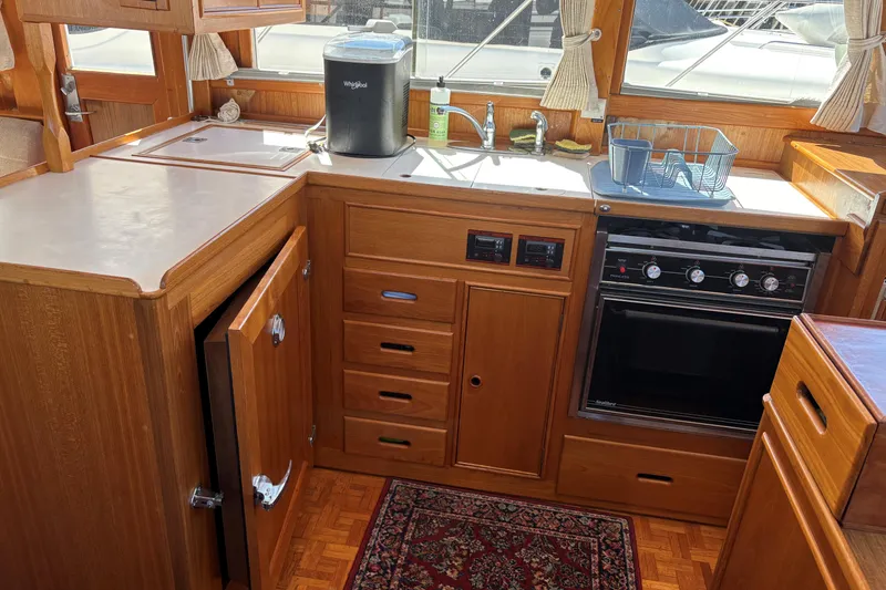 Slide: The Image of 1990 Grand Banks Classic yacht kitchen with wood cabinetry, oven, and sink. - 9
