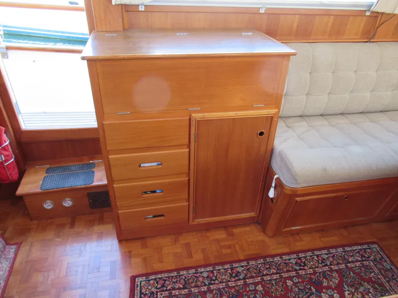 Slide: The Image of 1990 Grand Banks Classic interior with wooden cabinetry and cushioned seating. - 11