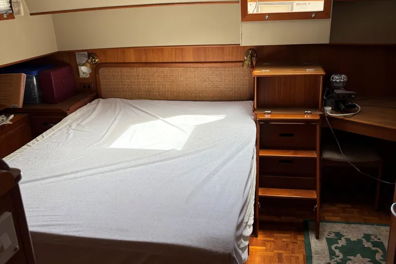 Slide: The Image of Cozy bedroom interior of 1990 Grand Banks Classic yacht with wooden furnishings and natural light. - 12
