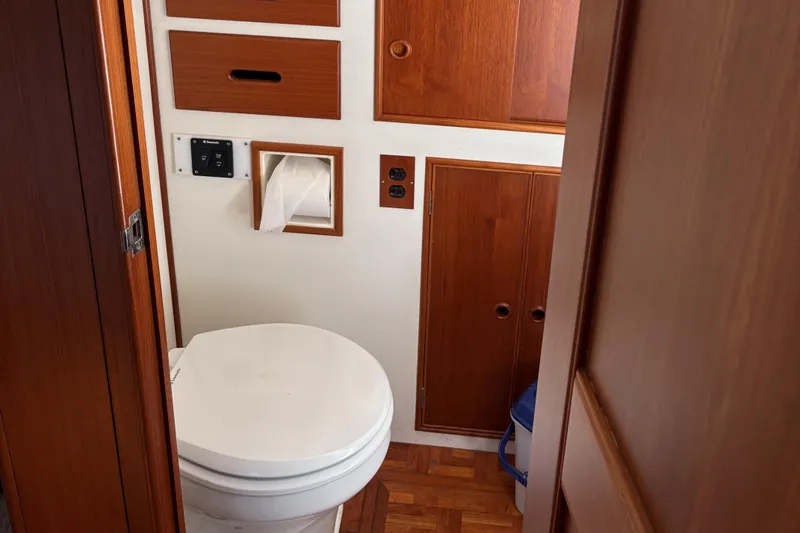 Slide: The Image of 1990 Grand Banks Classic boat bathroom with wooden cabinets and white toilet. - 14
