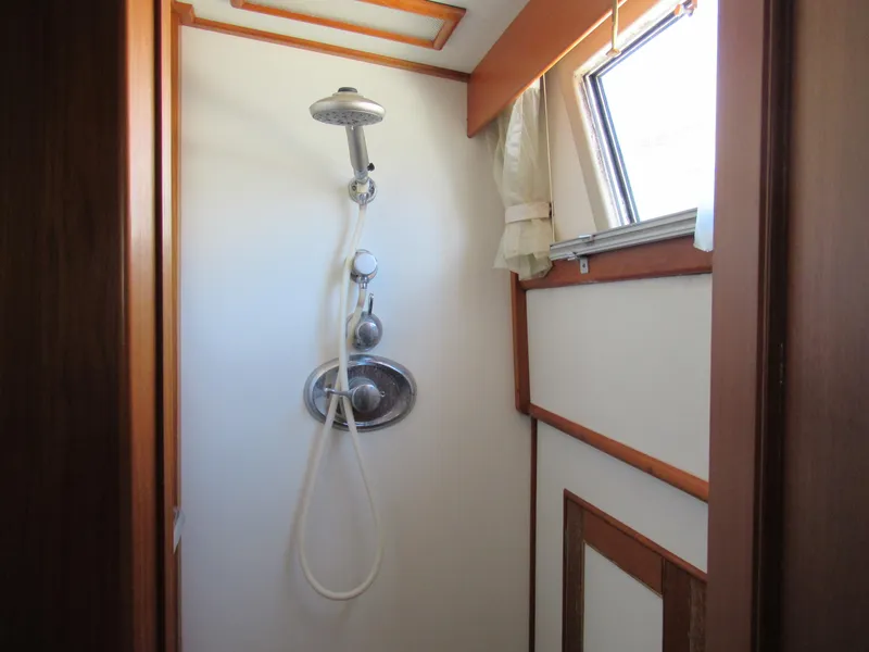 Slide: The Image of Shower area in 1990 Grand Banks Classic boat with wooden trim and window. - 15