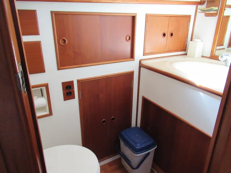 Slide: The Image of 1990 Grand Banks Classic yacht bathroom with wooden cabinets and white fixtures. - 17