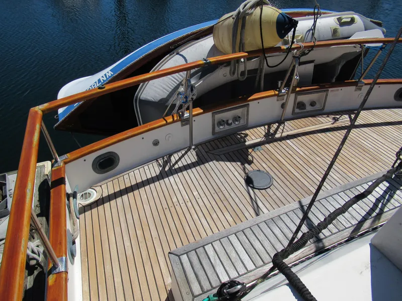 Slide: The Image of 1990 Grand Banks Classic yacht deck with wooden finish and lifeboat. - 4