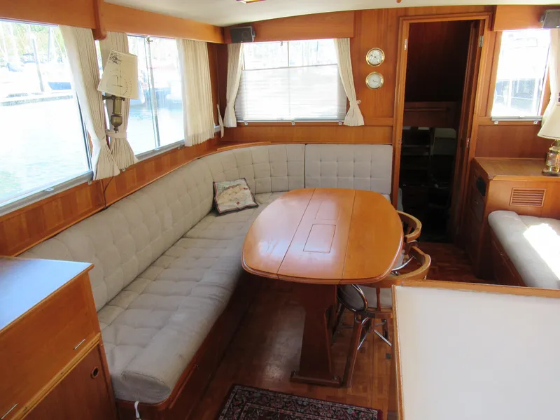 Slide: The Image of Interior of a 1990 Grand Banks Classic yacht with wooden dining area and cushioned seating. - 5