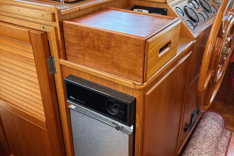 Slide: The Image of 1990 Grand Banks Classic yacht interior with wooden cabinetry and control panel. - 8