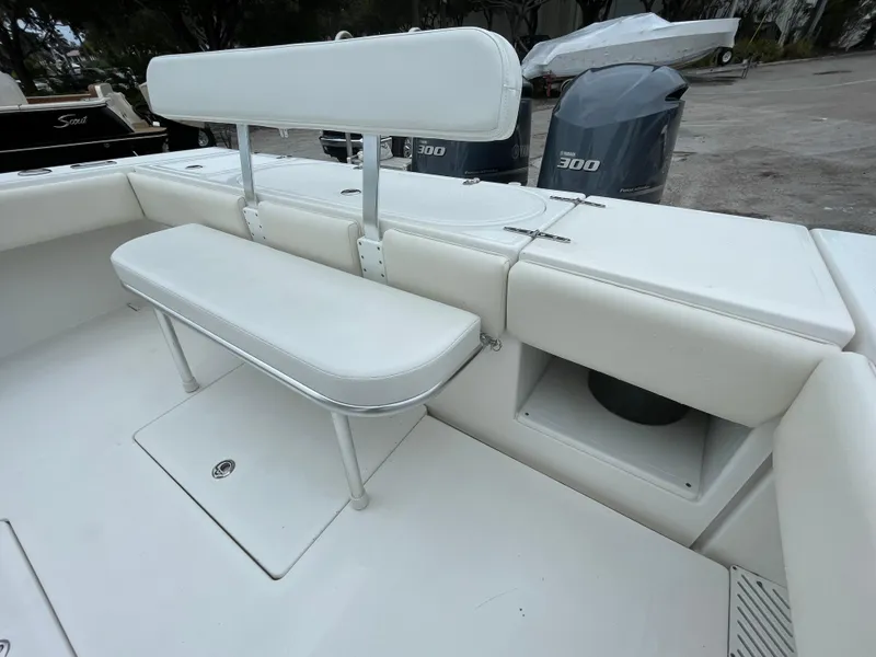 Slide: The Image of Venture 34 Tournament 2000 boat seating area with white cushions and storage compartment. - 22