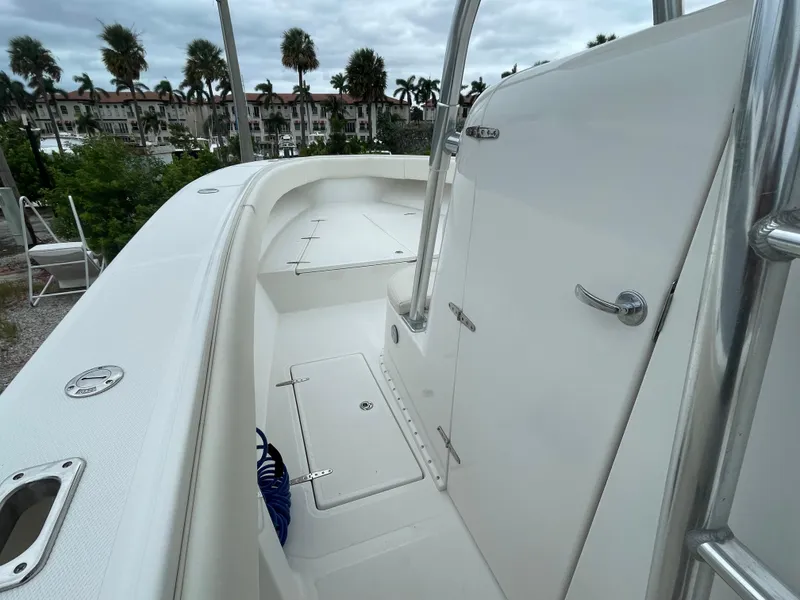 Slide: The Image of 2000 Venture 34 Tournament boat deck with storage compartments and railing, surrounded by palm trees. - 24