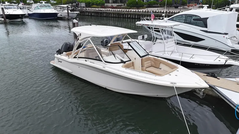 The Image of 2019 Scout 255 Dorado boat docked in a marina, surrounded by other vessels. - 0
