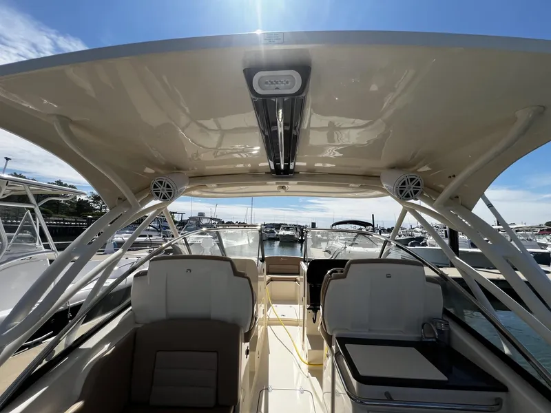 Slide: The Image of 2019 Scout 255 Dorado boat interior with seating and canopy, docked at marina. - 10