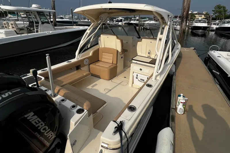 Slide: The Image of 2019 Scout 255 Dorado boat docked, featuring spacious seating and Mercury engines. - 3