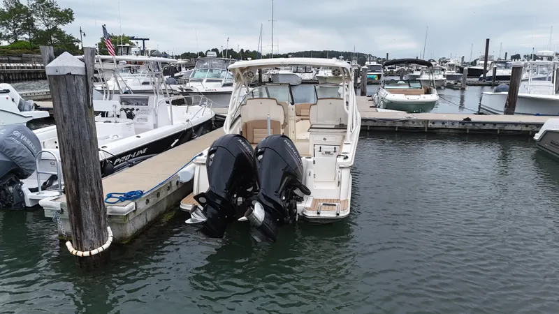 Slide: The Image of 2019 Scout 255 Dorado boat docked in a marina with twin outboard engines. - 4
