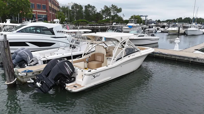 Slide: The Image of 2019 Scout 255 Dorado boat docked in a marina with other vessels. - 5