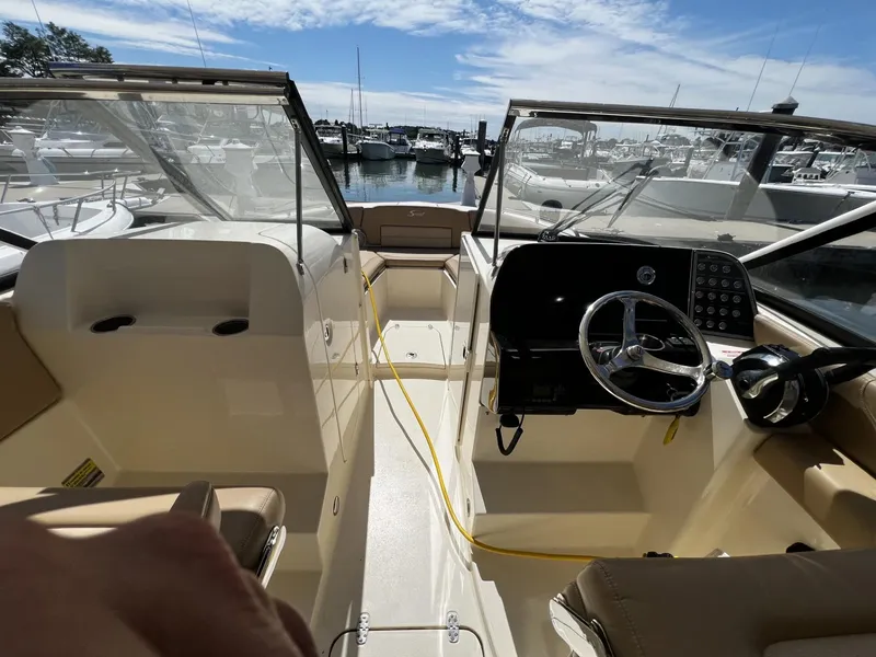 Slide: The Image of 2019 Scout 255 Dorado boat interior with steering wheel, docked at marina. - 8