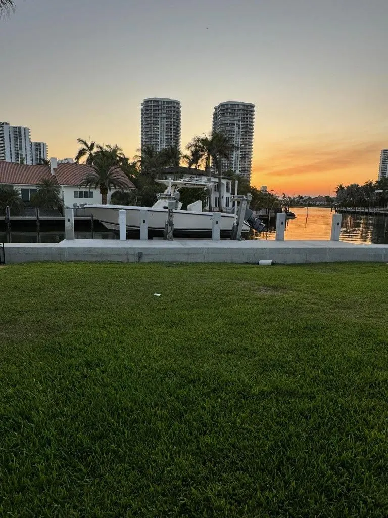 Slide: The Image of 2013 Pursuit C 260 Center Console boat docked at sunset with cityscape background. - 0