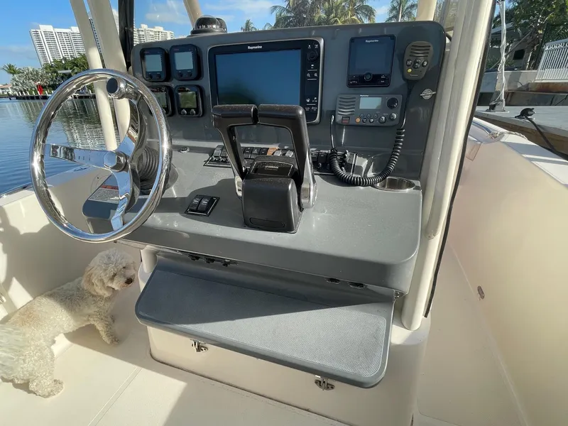 Slide: The Image of 2013 Pursuit C 260 Center Console helm with navigation equipment and a small dog nearby. - 10