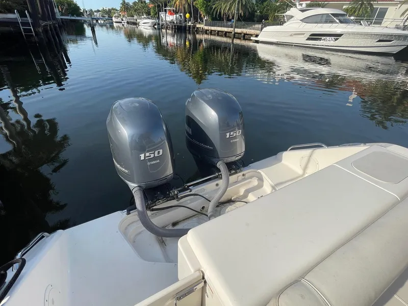 Slide: The Image of 2013 Pursuit C 260 Center Console with twin Yamaha 150 engines docked by waterfront. - 12