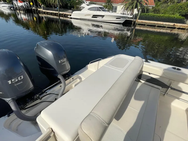 Slide: The Image of 2013 Pursuit C 260 Center Console boat with twin Yamaha 150 engines docked by waterfront. - 13