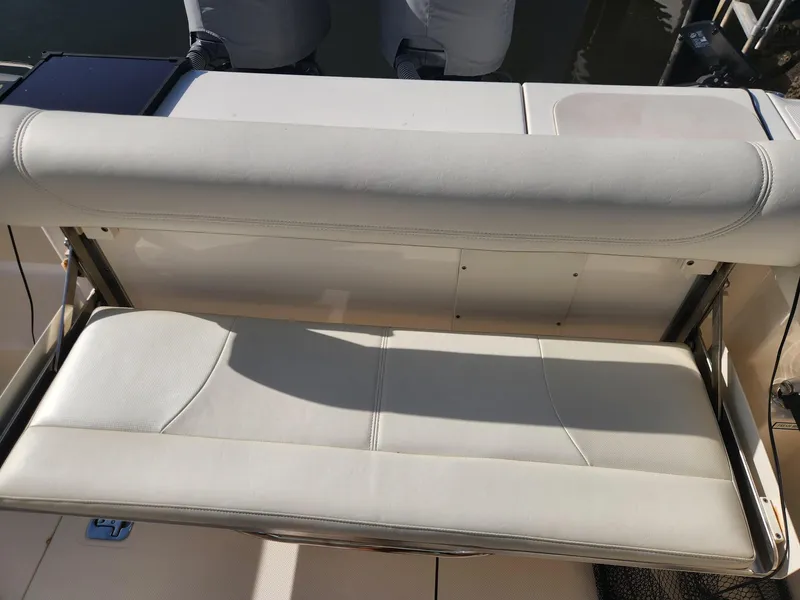Slide: The Image of 2013 Pursuit C 260 Center Console boat seat, white upholstery, outdoor setting. - 3