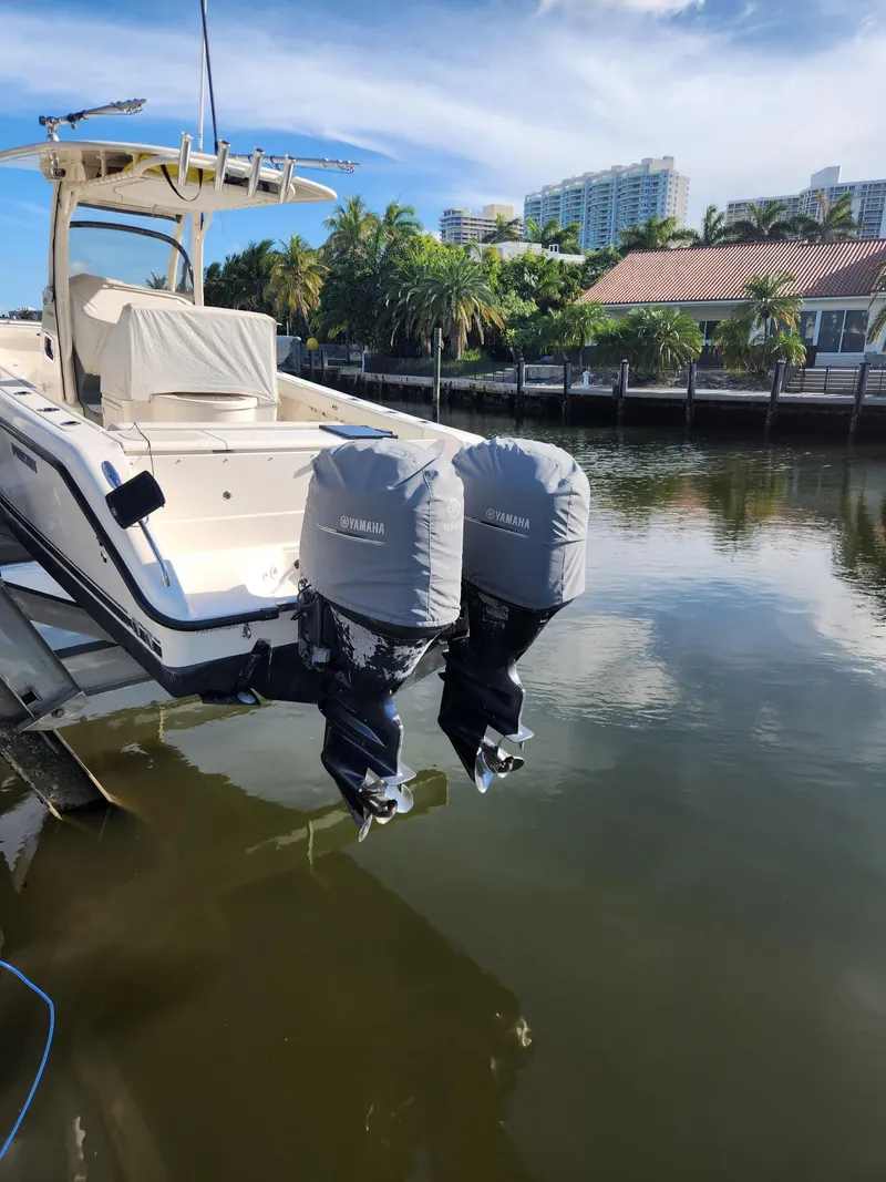 Slide: The Image of 2013 Pursuit C 260 Center Console boat with twin Yamaha engines docked by waterfront. - 4