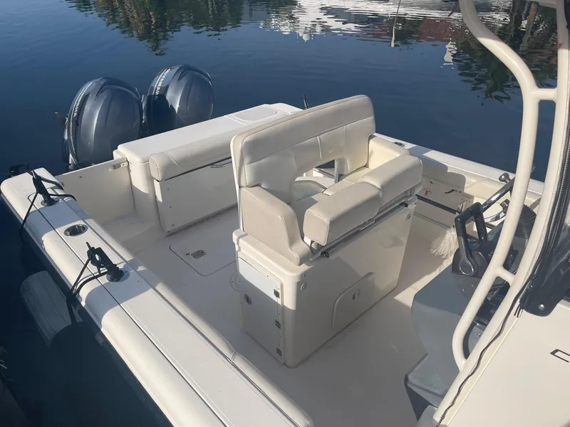 Slide: The Image of 2013 Pursuit C 260 Center Console boat with dual engines, docked on calm water. - 6