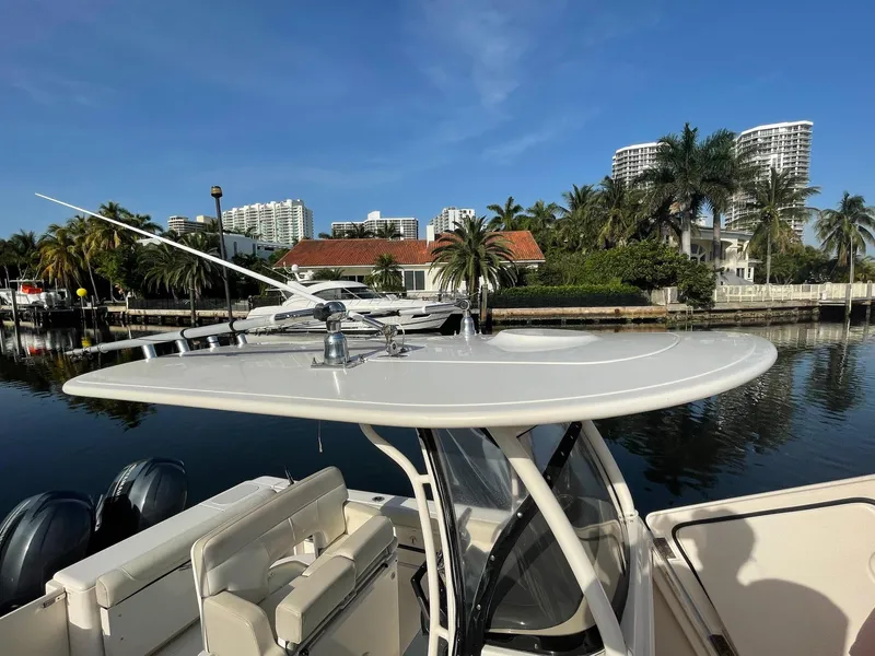 Slide: The Image of 2013 Pursuit C 260 Center Console boat docked near palm trees and waterfront buildings. - 7