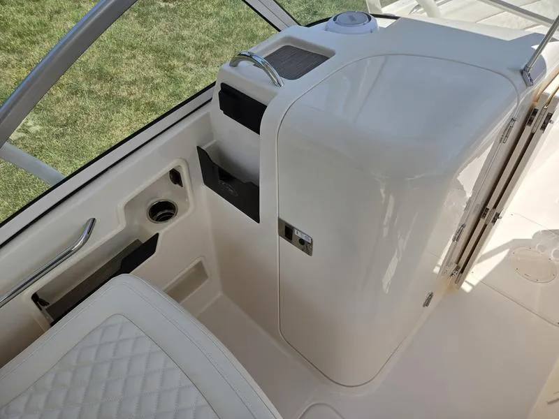 Slide: The Image of 2026 Grady-White Freedom 235 boat on trailer, parked on grass under clear blue sky. - 10