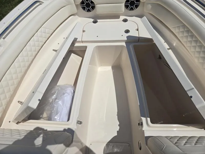 Slide: The Image of 2026 Grady-White Freedom 235 boat interior with white seating and storage compartments. - 13