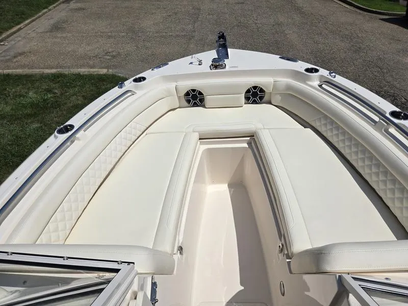 Slide: The Image of 2026 Grady-White Freedom 235 boat interior with white cushioned seating. - 17